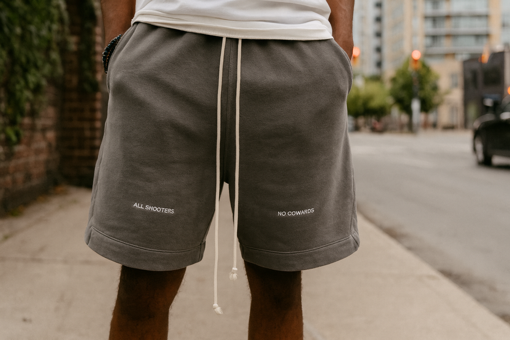 Person wearing gray shorts with text on a city street