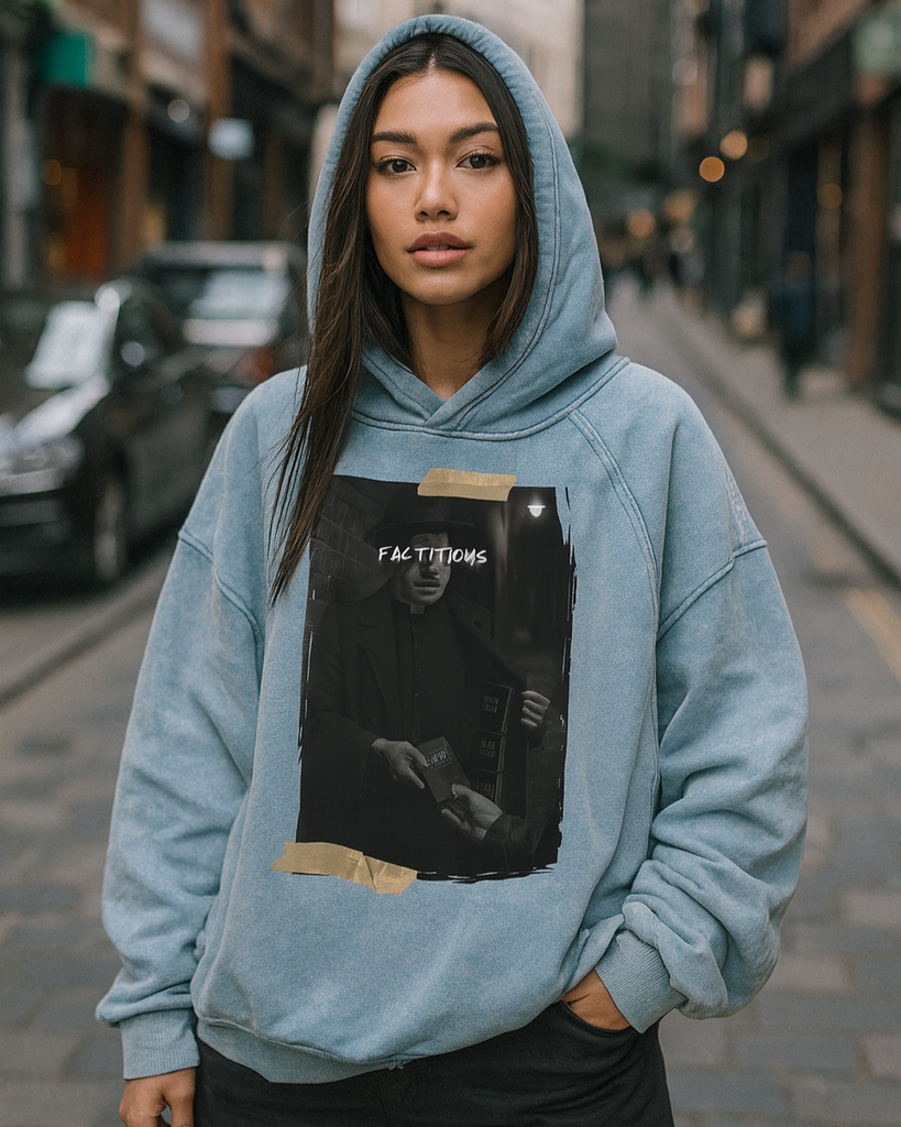 Person wearing a blue hoodie with a graphic design on a city street